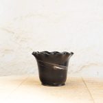 Ročno izdelan cvetlični lonec z marmoriranim vzorcem iz črne in bele gline, glaziran s prozorno glazuro in oblikovan z valovitim robom.