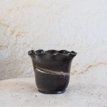 Ročno izdelan cvetlični lonec z marmoriranim vzorcem iz črne in bele gline, glaziran s prozorno glazuro in oblikovan z valovitim robom.