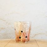 Ročno izdelan cvetlični lonec iz bele šamotne gline, dekoriran z ognjenimi potezami in črnimi pikami, ki simbolizirajo pepel v zraku.