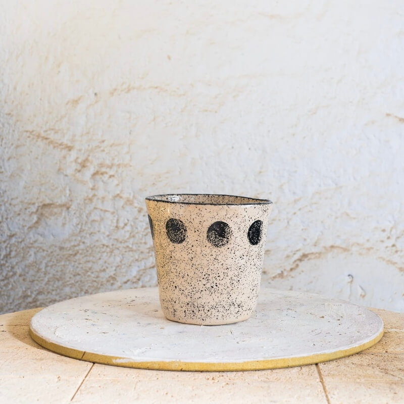 Ročno izdelan beli cvetlični lonec z drobnimi kamenčki in črnim vzorcem krogov, primeren za sodobne skandinavske interierje.