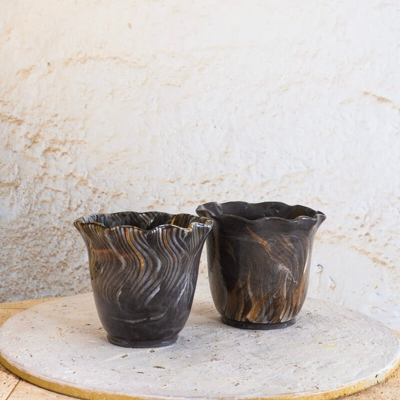 Ročno izdelana cvetlična lonca iz črne gline Nigra z valovitimi robovi, dekorirana z belo engobo in nežno pozlato.