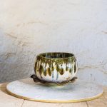 Ročno izdelan keramični lonec s podstavkom v obliki lista. Narejen s tehniko kačic, glaziran z belo craque in zeleno efekt glazuro. Z luknjicami za odtekanje vode – popoln za sukulente, zelišča ali rastline z dušo.